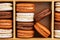 Brown and white french macarons or macaroons, chocolate, coffee, toffee and vanilla stacked in a bamboo box