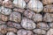 Brown and white large porous round and oval stone pile background. Natural environmental decorative material behind a metal mesh.