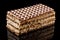 Brown and white puff waffle cake with boiled condensed milk isolated on black background with reflection on glossy surface