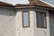 Brown windows on white brick wall of attic