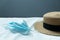 Brown women summer hat with white blue corona virus protection health mask on indoor background