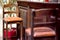 Brown wood bar stool with high legs and leather seat.