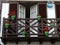 Brown wooden balcony in fishermen district downtown in Hondarribia, Basque country, Spain. Pots with flowers of green and red