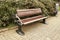 Brown wooden bench with a green meadow in the background. Lonely chairs on the lawn in the park.