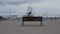 Brown wooden bench and metal structure to sit in the middle of a marina in Spain on a cloudy day