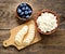 Brown wooden Bowl of homemade curd with banana, jam, blueberries