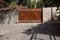 Brown wooden car close gate and a flowering wall