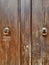 Brown wooden door with door pulls. Aged. Double wing. Solid