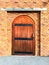 Brown wooden door with red brick wall