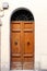 Brown wooden doors in a stone archway wall