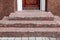 Brown wooden entrance door with a stone threshold .