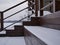 The brown wooden staircase is covered with a layer of snow without traces. Steps with railings to the river .