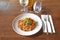 Brown wooden table and White plate with ragu sauce on Linguine