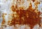 Brown and yellow rust on white enamel, corroded metal background. Rusty painted metal wall