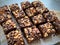 Brownie cubes with chocolate pieces and nuts, top view.Flat lay food