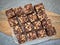 Brownie cubes with chocolate pieces and nuts, top view.Flat lay food