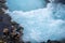 Bruarfoss, Iceland - July 9, 2023: Father helps his son fill a water bottle from a dangerous river stream in Iceland, holding his