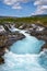 Bruarfoss waterfall on a sunny day in summer. Features beautiful teal turquoise water in Iceland along the Golden Circle area