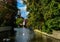 Bruges, Belgium. August 2019. View towards the historic center from the bridge with the Sashuis lock. The canal leads the eye