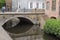 Bruges, Belgium - May 12, 2018: Stone Bridge Above A Water Channel