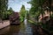 Bruges canals on a sunny day with white clouds. Picturesque landscape Swans swimming in the canal