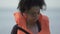 Bruised female refugee holding life vest, looking at camera, catastrophe victim