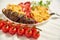 Brunch of fresh cherry tomatoes on white cloth close up. Fried potatoes, eggplant, bell pepper and cauliflower on white plate