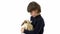 Brunet boy is holding and stroking three colored rabbit at white background. Slow motion.