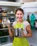 Brunette in apron looking at products in refrigerator