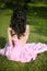 Brunette bride resting and sitting on green grass at spring park