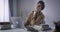 Brunette Caucasian boy moving stiff neck as sitting at the table with laptop. Portrait of male college student having