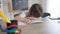 Brunette Caucasian schoolboy crying at desk in classroom. Portrait of upset overwhelmed boy sitting in school indoors