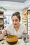 Brunette craftswoman holding plastic cup while