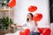 Brunette European girl rejoices playing on bed with red heart shape balloons. Morning love surprise gift on valentines