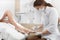 Brunette female podiatrist making polish and cleaning procedure for foot.