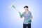 Brunette girl in a baseball cap and cleaning lady uniform washing a window with a special mop and smiles