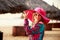 brunette girl in big red hat smiles at defocused umbrella