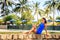 brunette girl in blue sits on stone barrier against pool