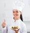 Brunette girl chef and plate with salad