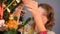 Brunette girl hanging Christmas toy on fir tree in the evening before holiday