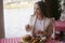 Brunette girl with long hair in a restaurant on ship on the background of the river. Girl tries burger and fries. Girl eats