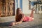 Brunette girl lying on the cobblestones in the central part of the old city in a sunny summer day