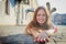 Brunette girl lying on the cobblestones in the central part of the old city in a sunny summer day