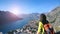 Brunette girl with an orange backpack enjoying the view of the Boka Bay in Montenegro. The view from the back