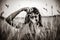 Brunette girl sitting at wheat field with camera.