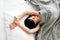 Brunette girl sleep under gray blanket top view