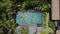 Brunette girl is swimming in outdoor pool on villa between tropical plants