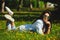 Brunette girl wears round sunglasses, lies on summer green grass.