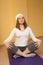 Brunette girl in white practicing yoga in the lotus position