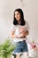 brunette girl in white t-shirt collects a bouquet of flowers from roses florist at work